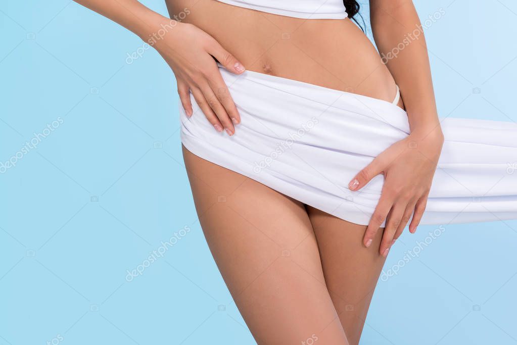 cropped view of slim girl posing with white chiffon, isolated on blue