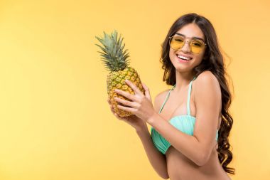 taze ananas, sarı izole tutan güzel gülümseyen kız