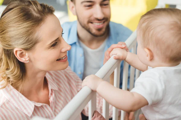 Young Parents Playing Infant Daughter Standing Crib — Stock Photo, Image