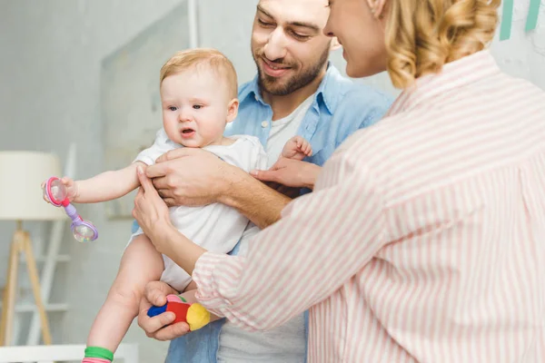 Young Parents Holding Infant Daughter Toy Hand — Stock Photo, Image