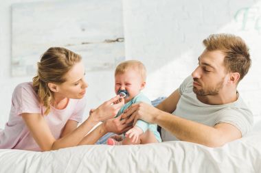 Genç anne bebek kukla ağlayan küçük kızıyla sakin olmaya çalışıyorum