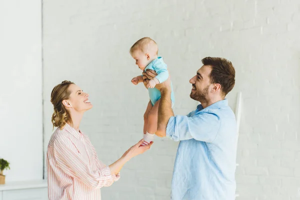 Padre Criando Hija Pequeña Mientras Madre Toca Sus Piernas —  Fotos de Stock