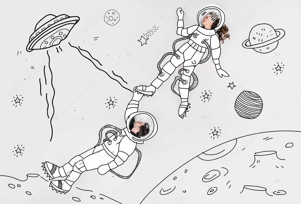 creative hand drawn collage with couple in space suits and ufo
