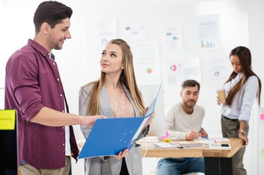 iş adamları iş ve arkasında çok ırklı meslektaşları Office klasörü ile seçici odak