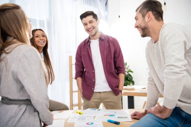 İşyeri ofis yeni pazarlama projesinin tartışırken çok ırklı iş arkadaşları gülümseyerek