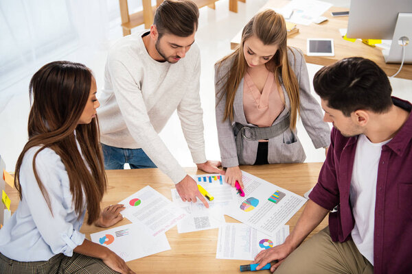 Коллеги по многонациональному бизнесу обсуждают новый маркетинговый проект на рабочем месте в офисе
