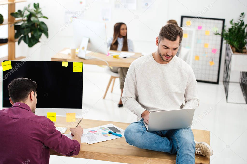 selective focus of businessmen working at workplace together in office