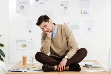 ofiste tabloda oturan genç sıkılmış iş adamı