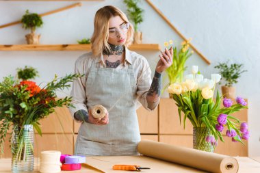 ipi tutan ve çiçeklerle işyerinde çalışma gözlük güzel genç çiçekçi