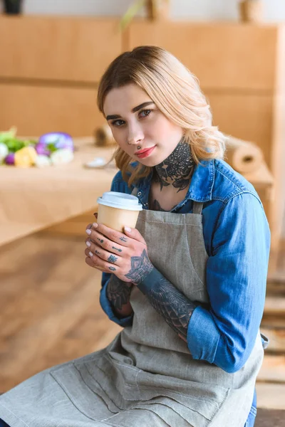 Beautiful Young Florist Holding Paper Cup Coffee Looking Camera — Free Stock Photo