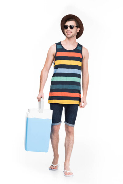 smiling man in summer hat holding cooler box, isolated on white