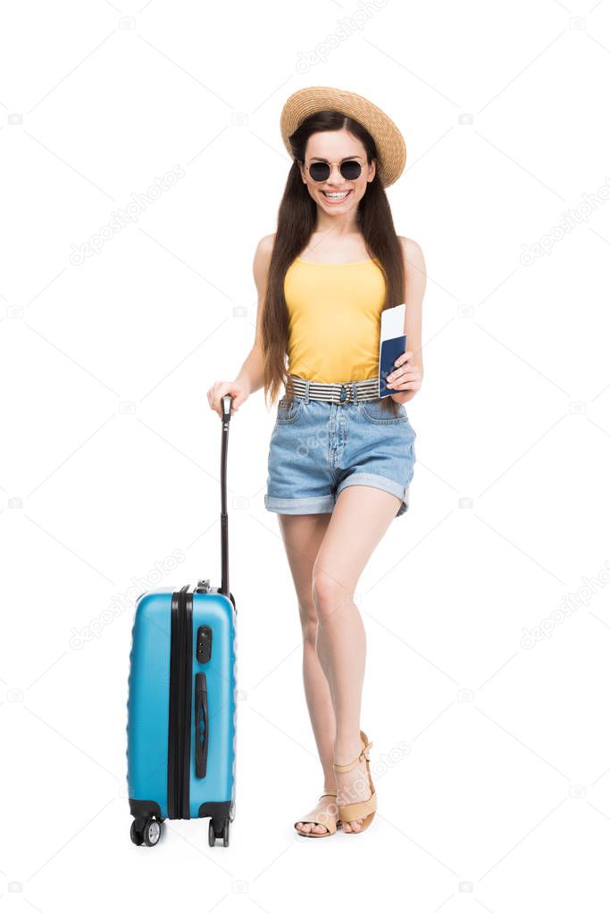 happy female traveler with passport, air ticket and baggage, isolated on white 