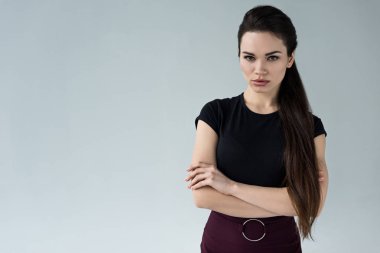 çapraz kolları üzerinde gri izole kamera bakıyor olan kendine güvenen kadın