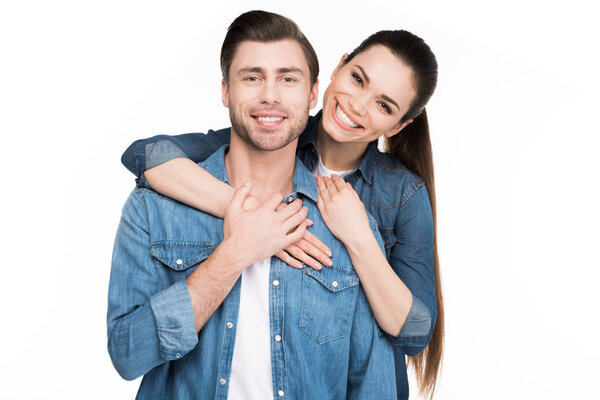 cheerful young couple hugging and looking at camera, isolated on white