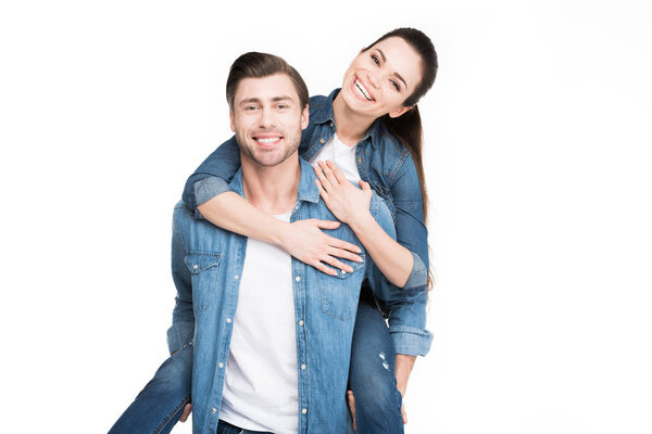 young smiling man piggybacking cheerful girlfriend, isolated on white