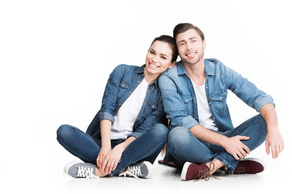 Casal Alegre Sentado Jeans Olhando Para Câmera Isolado Branco — Fotografia de Stock