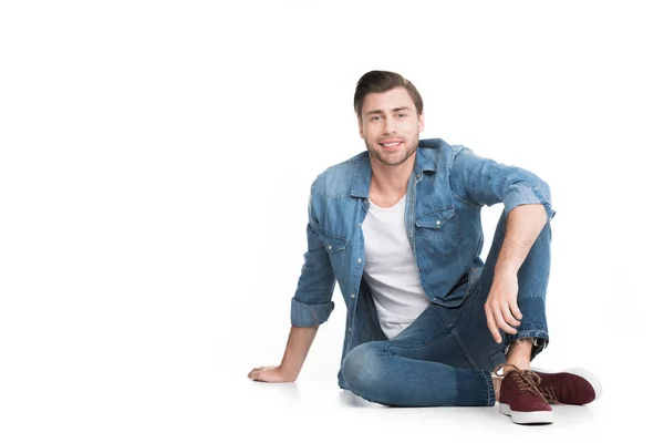 Jovem Jeans Sentado Sorrindo Para Câmera Isolado Branco — Fotografia de Stock Grátis