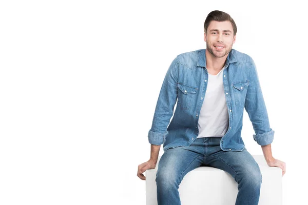 Bonito Sorridente Homem Sentado Branco Cubo Isolado Branco — Fotografia de Stock