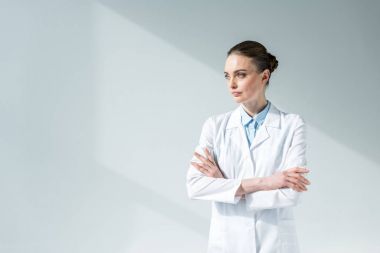 çapraz kolları uzakta gri görünümlü olan çekici kadın doktor