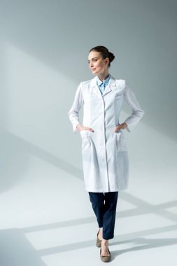 Beyaz önlük uzakta gri bakarak ciddi kadın doktor