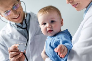 cropped shot of pediatricians checking breath of adorable little baby clipart