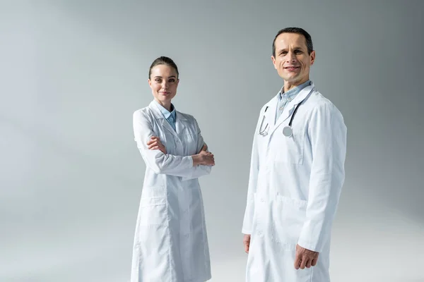 Médicos Adultos Sonrientes Mirando Cámara Aislada Gris — Foto de Stock