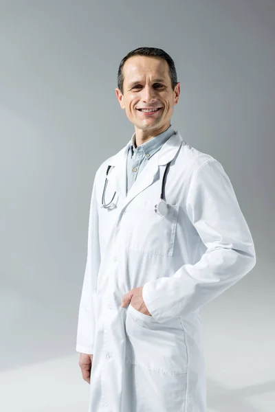 Médico Adulto Feliz Casaco Branco Olhando Para Câmera Isolada Cinza — Fotografia de Stock