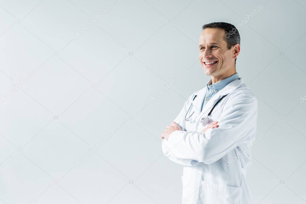 handsome adult doctor with crossed arms isolated on white