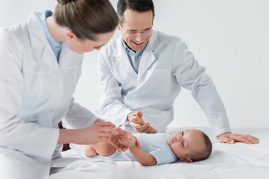 pediatricians preparing to perform vaccination to little baby clipart