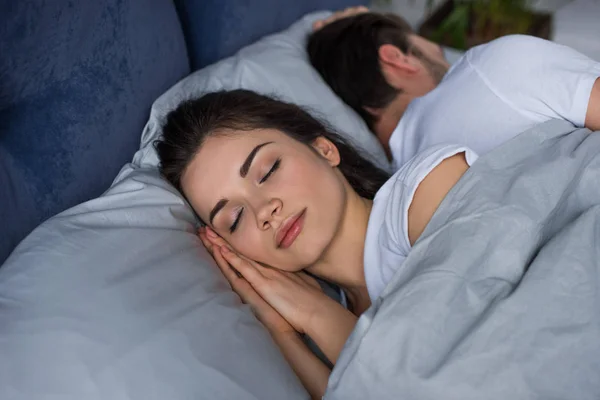 Νεαρή Γυναίκα Στον Ύπνο Από Τον Σύζυγό Της Στο Κρεβάτι — Φωτογραφία Αρχείου