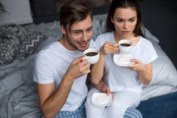 微笑的男人和女人在床上喝咖啡 — 免费的图库照片