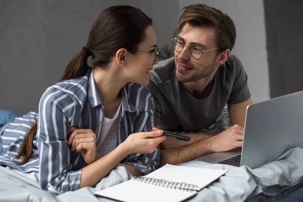 Cuplu Tânăr Scriind Notepad Lucrând Laptop Timp Stătea Pat — Fotografie, imagine de stoc