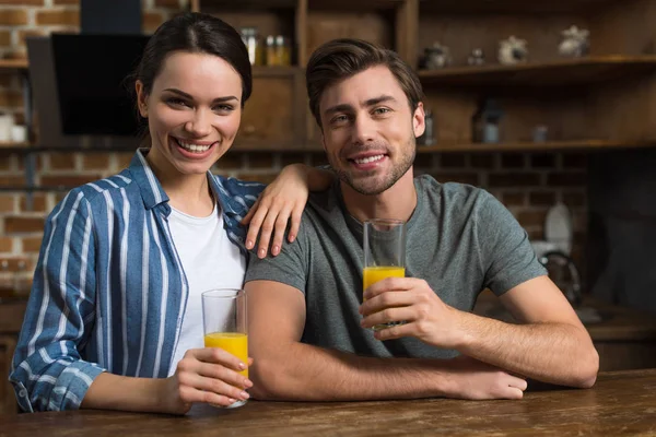 Sonriente Pareja Bebiendo Jugo Por Mesa Cocina — Foto de Stock