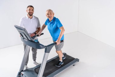 Komuta sizde treadmill egzersiz yardımcı rehabilitasyon terapist yüksek açılı görünüş 
