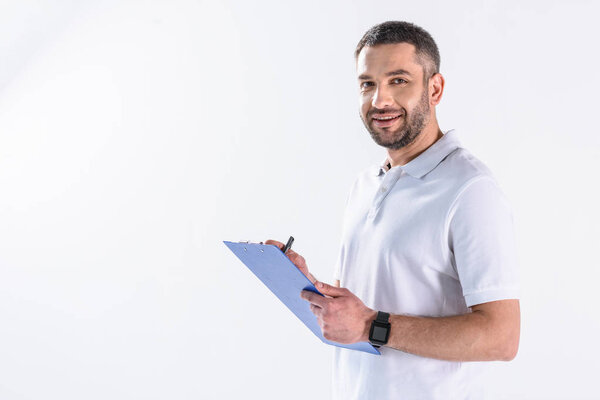 портрет улыбающегося реабилитационного терапевта с блокнотом, изолированным на сером
