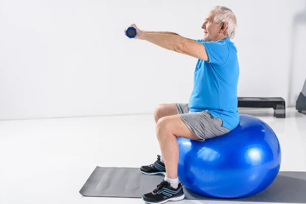 Visão Lateral Homem Sênior Com Halteres Exercendo Bola Fitness Fundo — Fotografia de Stock