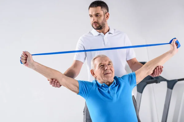 Retrato Del Terapeuta Rehabilitación Que Ayuda Hombre Mayor Hacer Ejercicio —  Fotos de Stock