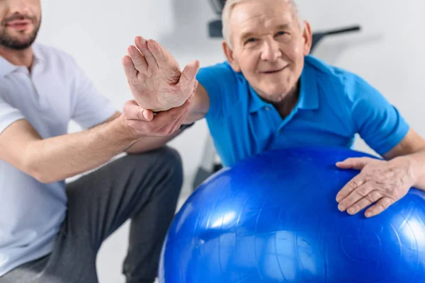 Egzersiz Fitness Topu Üzerinde Gülümseyen Kıdemli Adam Yardımcı Rehabilitasyon Terapist — Stok fotoğraf