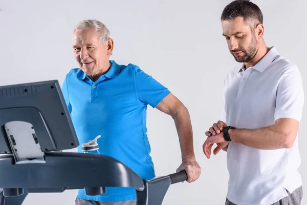 Rehabilitering Terapeut Kontroll Tid Bistå Senior Man Tränar Löpband Isolerad — Stockfoto