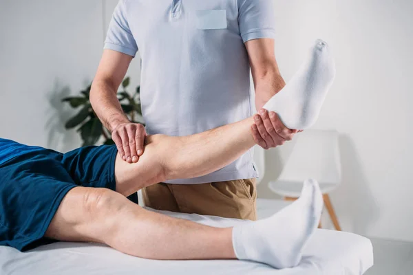 Tiro Cortado Fisioterapeuta Massageando Perna Homem Sênior Mesa Massagem — Fotografia de Stock
