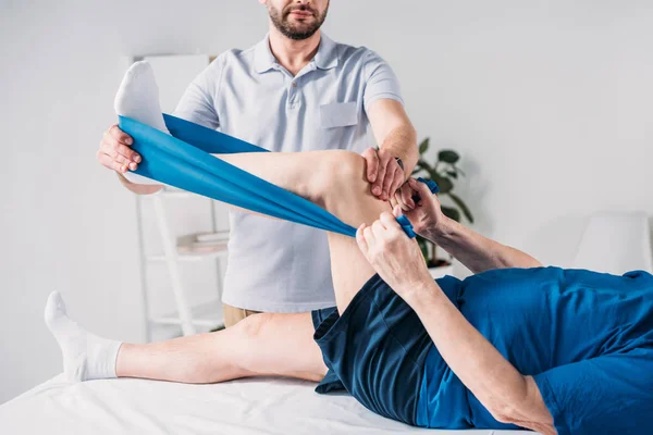 Cropped Shot Rehabilitation Therapist Assisting Senior Man Exercising Rubber Tape — Stock Photo, Image