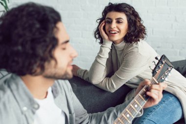 gitar çalmak ve gülümseyen kız evde şarkı erkek