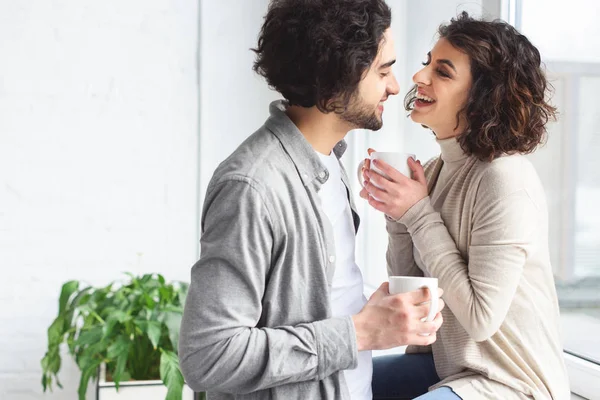 Young Couple Laughing Holding Cups Tea Home — Stock Photo, Image