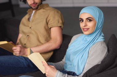 Müslüman çift evde kitap ile oturan kırpılmış görüntü