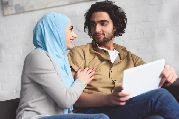 Pasangan Muslim Tersenyum Menggunakan Tablet Rumah — Foto Stok Gratis