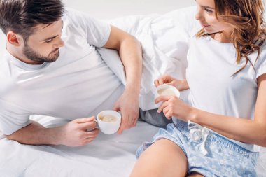 bardak kahve birlikte yatakta istirahat ile genç Çift