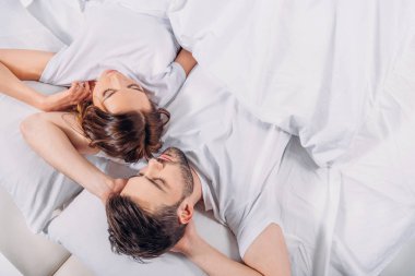 Genç çiftin yatakta yatmaya havai görünümü