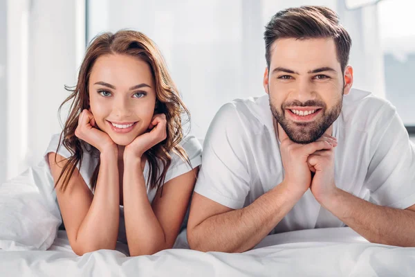 Portrait Smiling Couple Looking Camera While Resting Bed Together — Stock Photo, Image