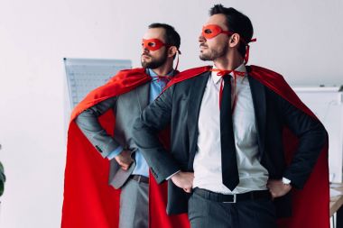 Maskeler ve ellerinde office akimbo ile ayakta burunları yakışıklı süper iş adamları