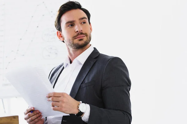 Guapo Hombre Negocios Sosteniendo Documentos Mirando Hacia Otro Lado Oficina — Foto de Stock